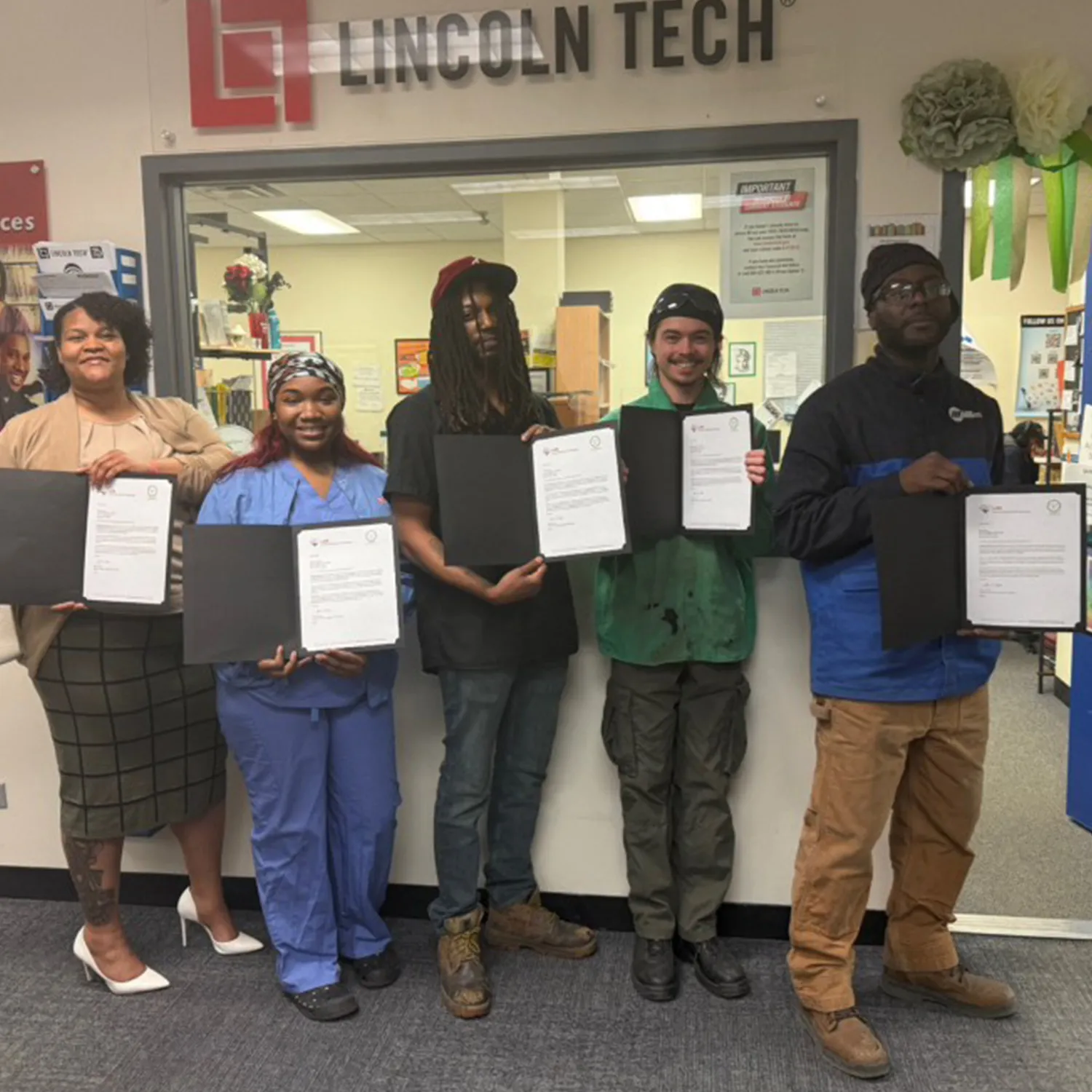 Five scholarship recipients and a mentor posing in front of the Lincoln Tech sign
