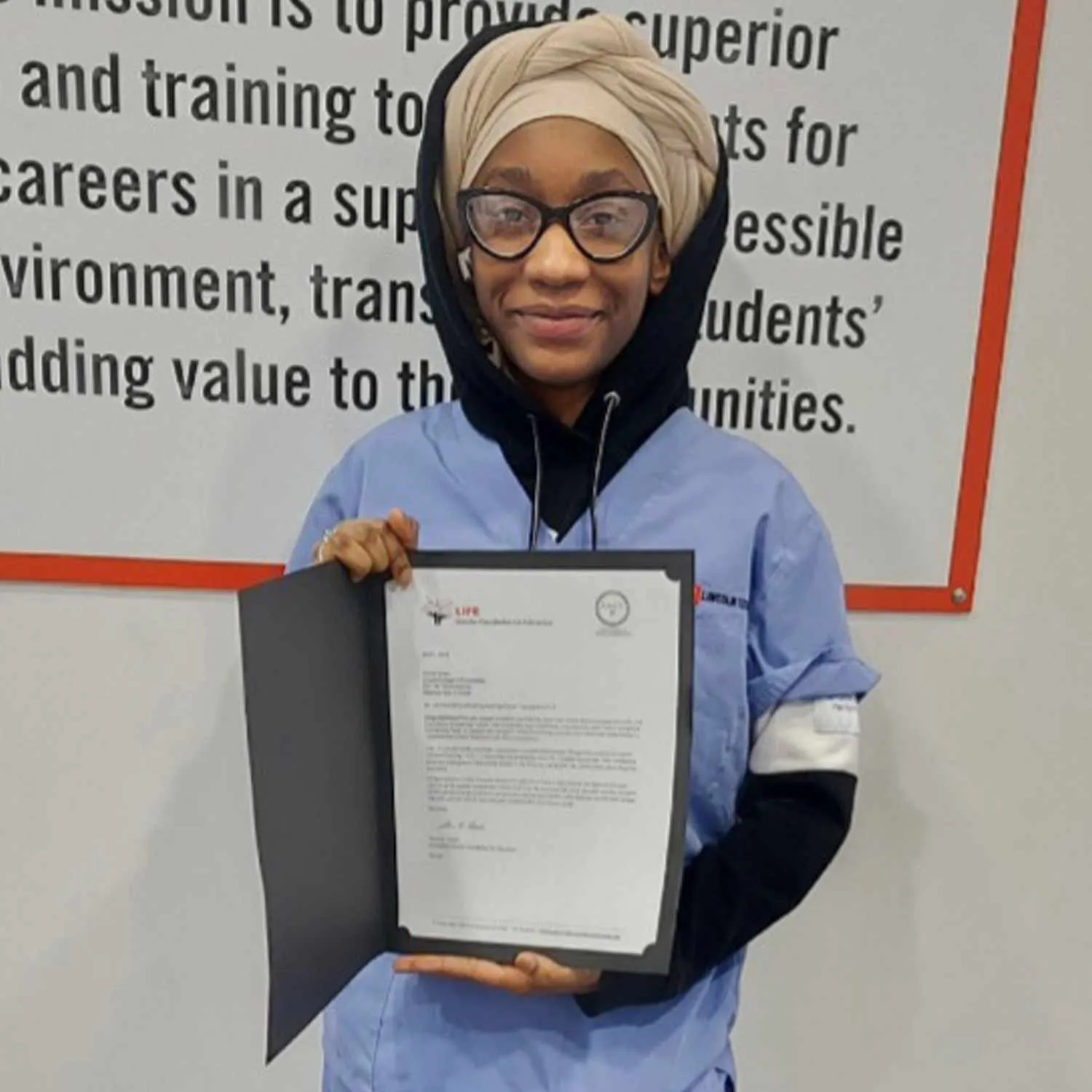 A Lincoln Tech student holding a scholarship certificate