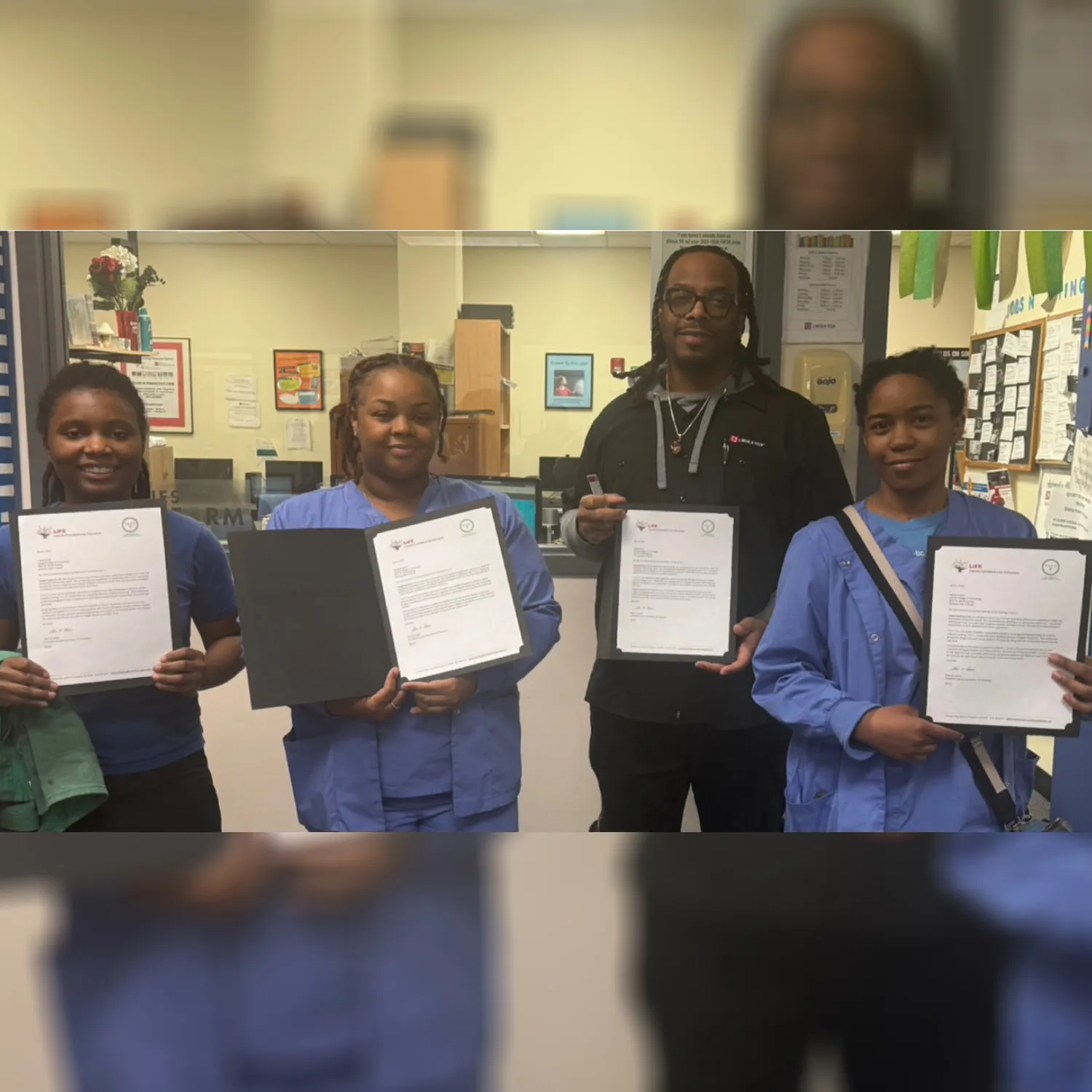 Four scholarship recipients holding certificates during the ceremony